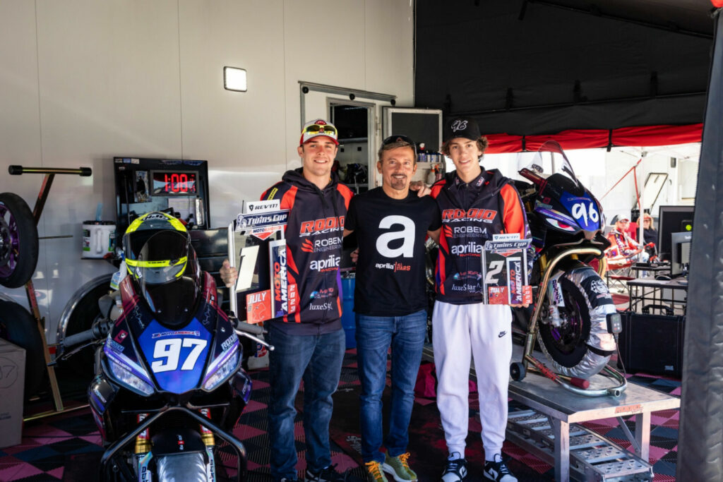 Six-time World Champion Max Biaggi (center) with Rocco Landers (left) and Gus Rodio (right). Photo by Sara Chappell Photos, courtesy Aprilia.