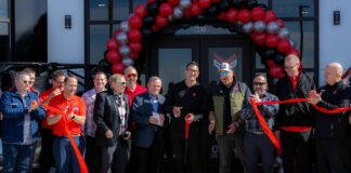 Rad Gladfelder (center holding red scissors), the General Manager of Young Honda Powerhouse, cuts the ribbon at the grand opening of Utah's newest powersports dealership. Photo courtesy Young Automotive Group.