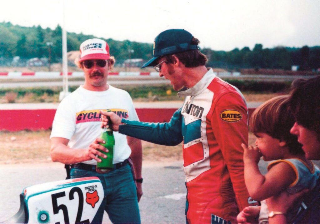 Chris Ulrich watches from his mother Trudy's arms as John Ulrich and mechanic Ken Hoogland share a bottle of champagne after a six-hour win at Loudon, New Hampshire, in 1981.