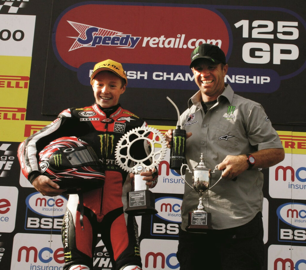 Dakota and Randy Mamola o a 2010 British 125cc GP podium. Photo by Turn One Photography.