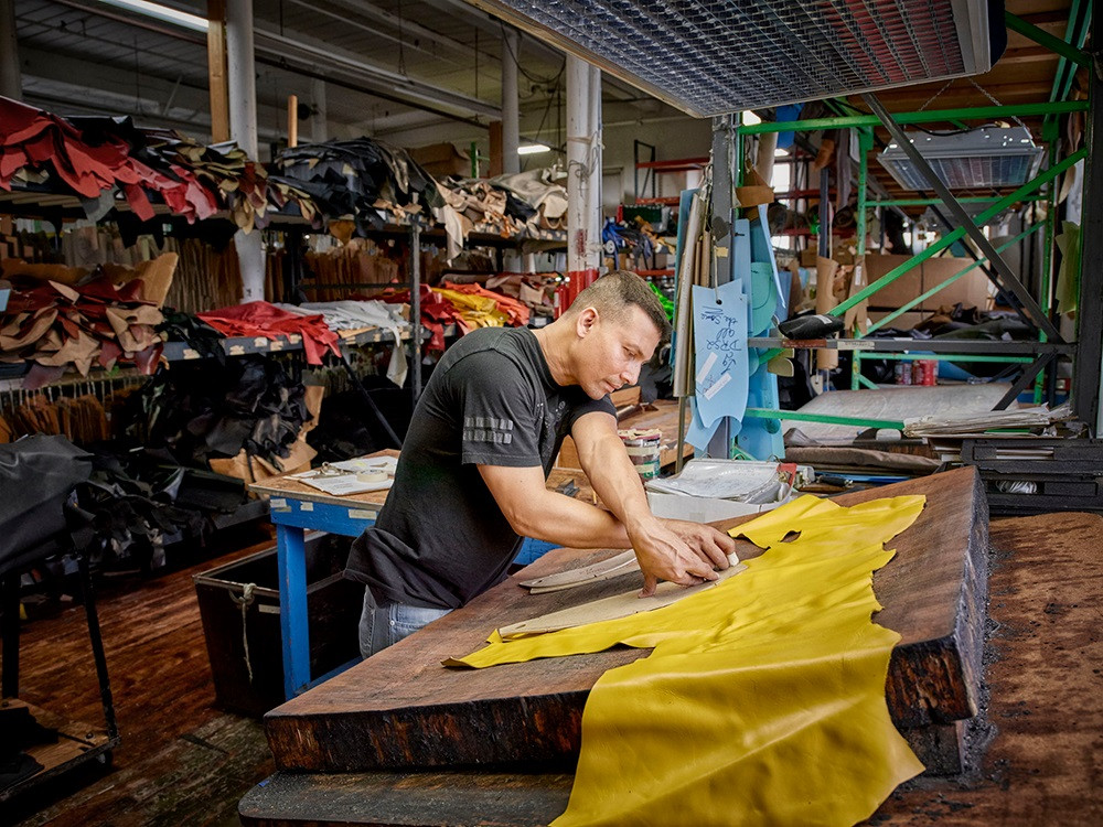 A Vanson Leathers employee hand-cutting leather at the factory. Photo courtesy Vanson Leathers.