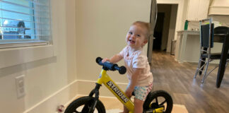 Olivia Grace "OG" Barnes and her Strider balance bike on its rocker base. Photo by Anne Barnes.