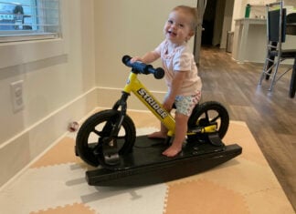 Olivia Grace "OG" Barnes and her Strider balance bike on its rocker base. Photo by Anne Barnes.