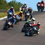 Geoff May (99), Stefano Mesa (37), Hayden Gillim (77X), Chris Fillmore (11R), Rennie Scaysbrook (33X), Gus Rodio (296), and Nate Kern (9T) during the 2023 AHRMA Pro Challenge race. Photo by etechphoto.com, courtesy AHRMA.