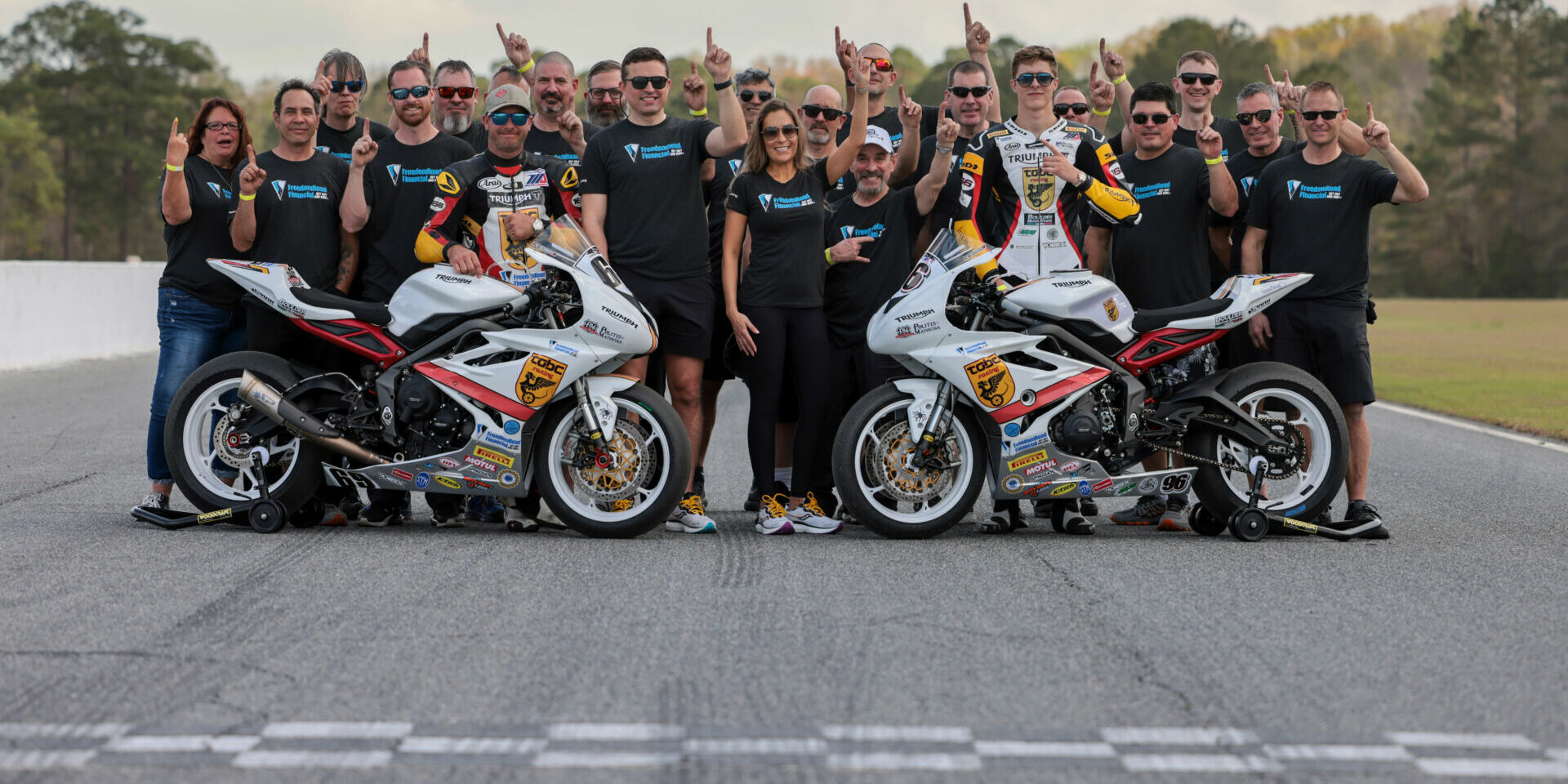 Michelle A. Lindsay (center) with husband Myles Wilson (to Lindsay's immediate right), riders Danny Eslick (left) and Brandon Paasch (right), and the rest of the TOBC Racing team ahead of the 2022 Daytona 200. Photo courtesy Triumph.